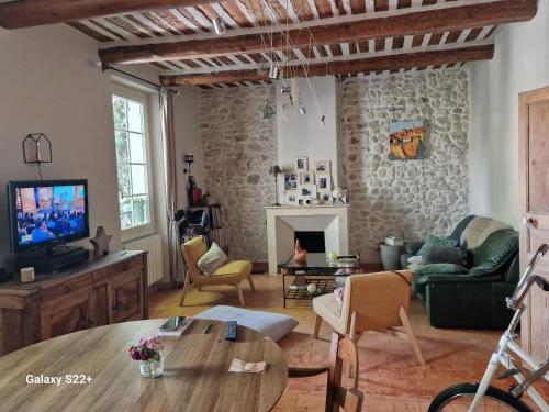 a living room with a couch and a tv at chambre entre Nesque et Ventoux in Mormoiron