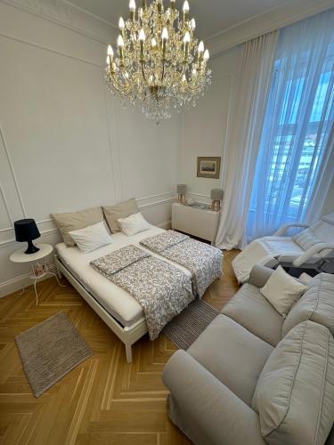 a bedroom with a bed and a couch and a chandelier at Royal Residence Schönbrunn in Vienna