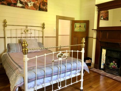 a bedroom with a bed and a fireplace at Riverwood Cottage, accessible accommodation in Warburton