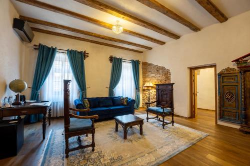 a living room with a blue couch and a table at The Throne - M Museum Hotel in Sighişoara