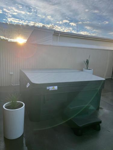 a large tub sitting on a patio with two plants at T Two Salty Shack - right across from the beach! in Papamoa