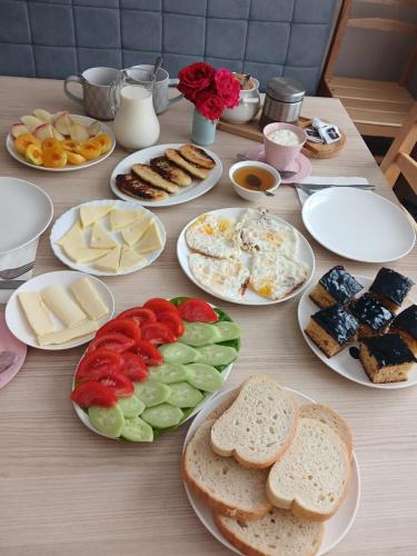 a wooden table with plates of food on it at Guesthouse in Lankhvri in Mestia