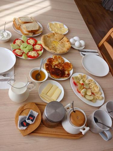 a table with plates of food and cups of coffee at Guesthouse in Lankhvri in Mestia