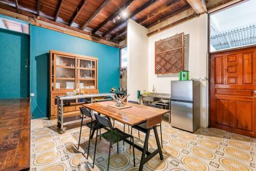 a kitchen with a wooden table and a refrigerator at Sleepinn Bang Chak in Bangkok