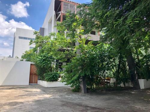 a white building with trees in front of it at Sleepinn Bang Chak in Bangkok