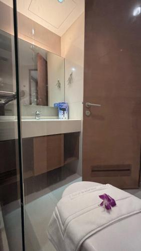 a bathroom with a sink and a door with a purple bow at Sam Homestay in Bangkok