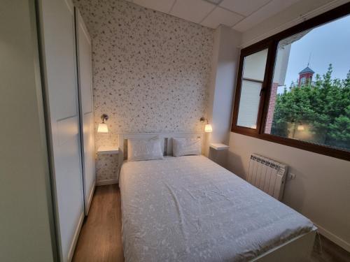 a small bedroom with a bed and a window at Los cañones in Liérganes
