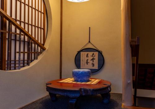 a room with a table with a clock on the wall at 虎屋別館 in Kotohira