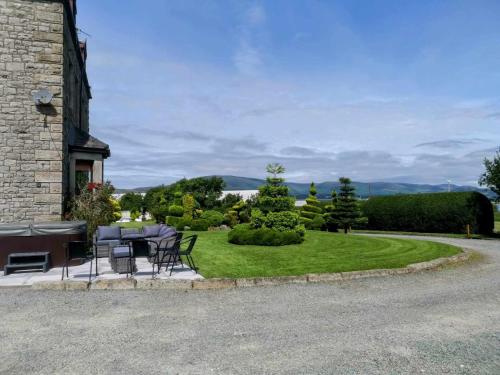 a patio with a table and chairs on a lawn at Duddon Villa in Millom