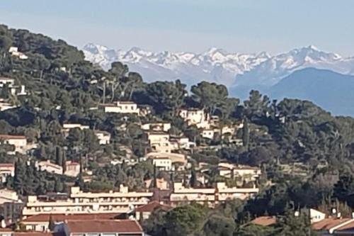 une ville sur une colline avec des montagnes en arrière-plan dans l'établissement les horizons, à Vallauris