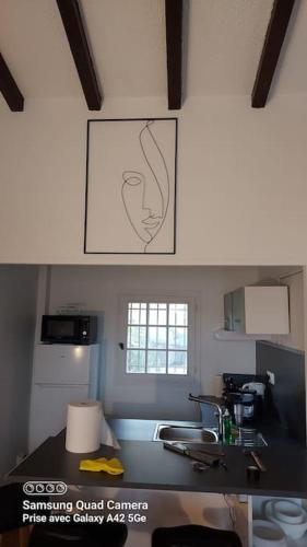 une cuisine avec un comptoir et un tableau sur le mur dans l'établissement les horizons, à Vallauris