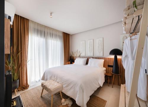 a bedroom with a white bed and a large window at Contessa Suites in Lefkada Town