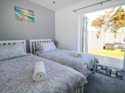 a bedroom with two beds and a large window at Sea View in South Hayling