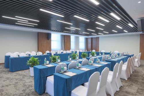 a conference room with blue tables and white chairs at SSAW Boutique Hotel Hangzhou East - Free Self Service Laundry in Hangzhou
