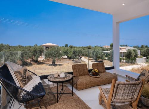 a living room with a large window with chairs and a table at Contessa Suites in Lefkada Town