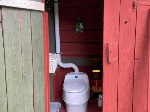 a toilet sitting inside of a red building at 4 person holiday home in NYKVARN in Nykvarn