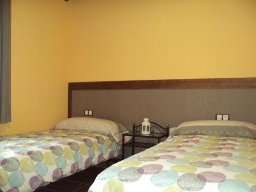 two beds sitting next to each other in a bedroom at Casa Rural O Fraginal in Guasillo