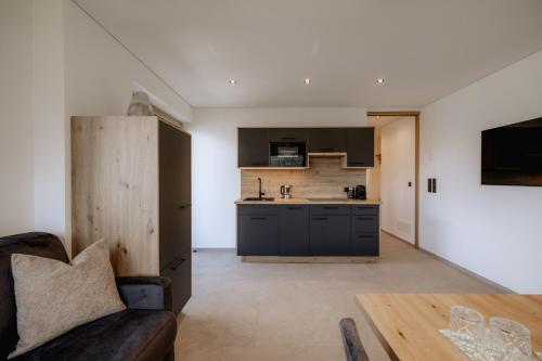 a kitchen and living room with a couch and a table at Ortsried-Hof in Laces