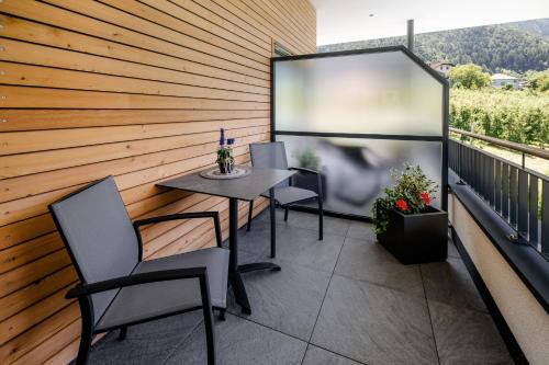 a balcony with a table and chairs and a screen at Ortsried-Hof in Laces