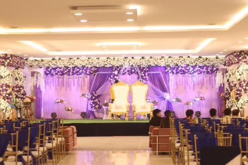 a wedding banquet hall with purple and purple drapes at The Retreat in Mirzāpur