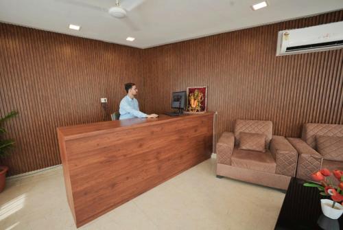a man standing at a counter in a waiting room at The Retreat in Mirzāpur