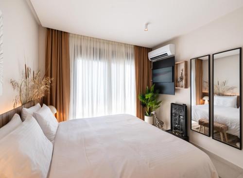a bedroom with a large white bed and a window at Contessa Suites in Lefkada Town
