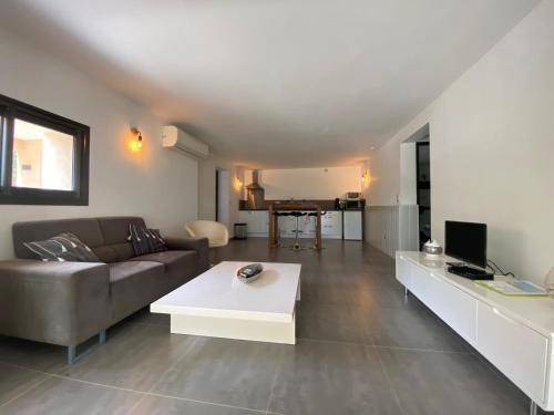 un salon avec un canapé et une table dans l'établissement Bas de villa - Canella, à Sari-Solenzara