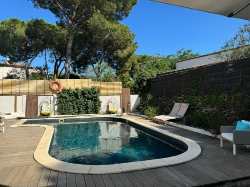 - une piscine dans un jardin avec une terrasse en bois dans l'établissement Dbarka7, à Sète