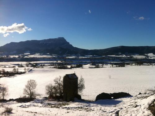 a snow covered field with a mountain in the background at Casa Rural O Fraginal in Guasillo