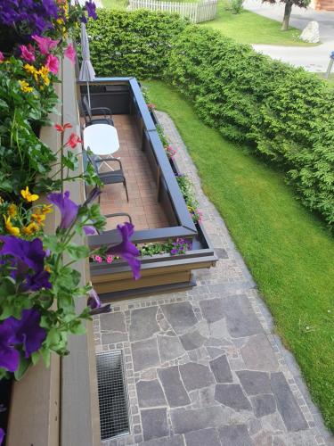 a garden with two benches and flowers on a balcony at Appartements Winter Anita in Flachau