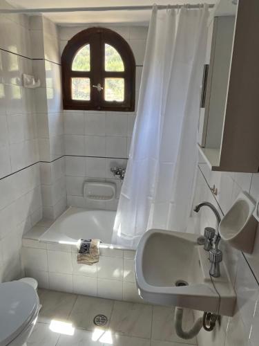 a bathroom with a tub and a sink and a toilet at White House Mochlos in Mochlos