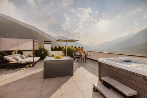 a patio with a hot tub and a table and chairs at Ortsried-Hof in Laces
