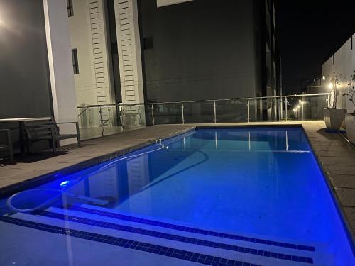 a blue swimming pool on top of a building at night at Cozy Retreat in Carlswald 229 in Midrand
