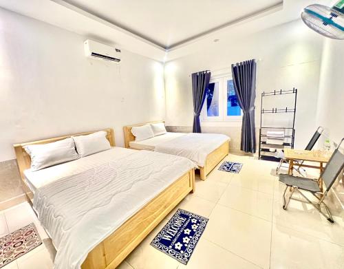une chambre avec deux lits, un bureau et une chaise dans l'établissement Star Hotel - Khách sạn giá bình dân, à Vung Tau