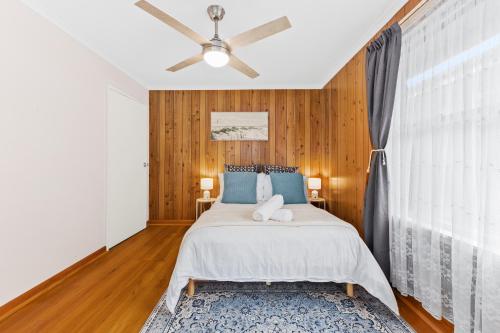 Un dormitorio con una cama y un ventilador de techo. en Retro Retreat - Mornington, en Mornington
