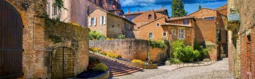 an alley with brick buildings and a stairway at Appartement climatisé avec parking à Albi in Albi