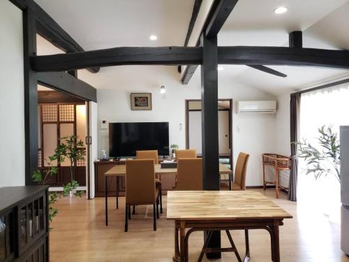 a dining room with a table and chairs at ゲストハウス　風の丘 in Aji