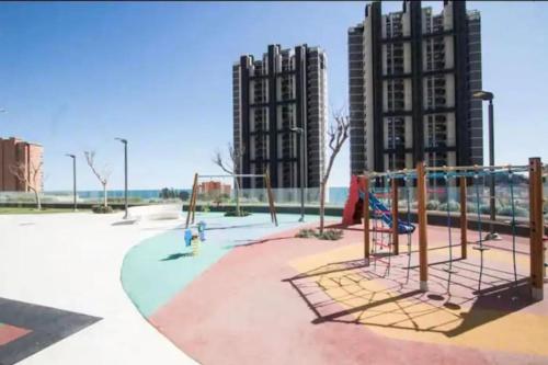 een lege speeltuin in een park met hoge gebouwen bij Intempo 31 panoramic sunrise & spa in Benidorm