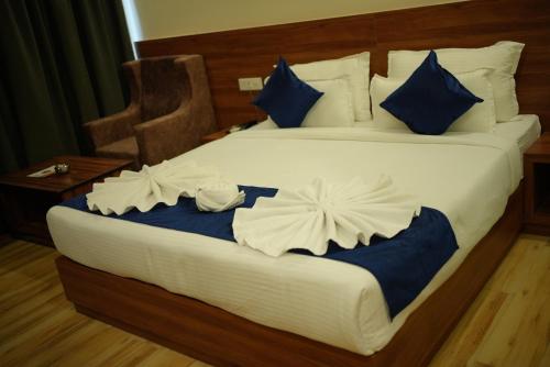 a bedroom with a large bed with blue and white pillows at HOTEL MAKHAN VIHAR in Ambikāpur