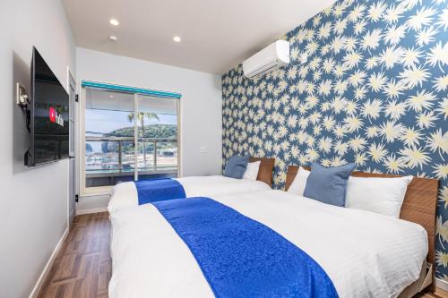 a bedroom with two beds and a window at Daikyo Engtsuto Villa in Shirahama