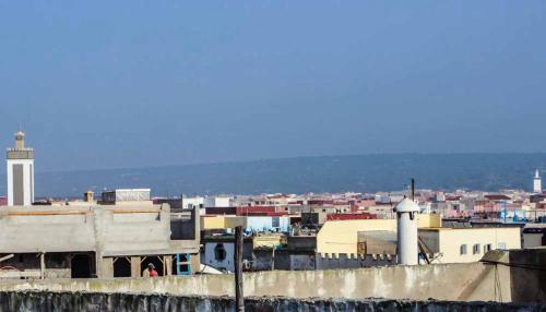 a view of a city with buildings and a lighthouse at White And Blue in Essaouira