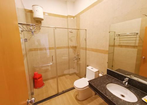 a bathroom with a shower and a sink and a toilet at The Retreat in Mirzāpur