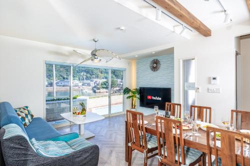 a dining room with a table and chairs and a television at Daikyo Engtsuto Villa in Shirahama