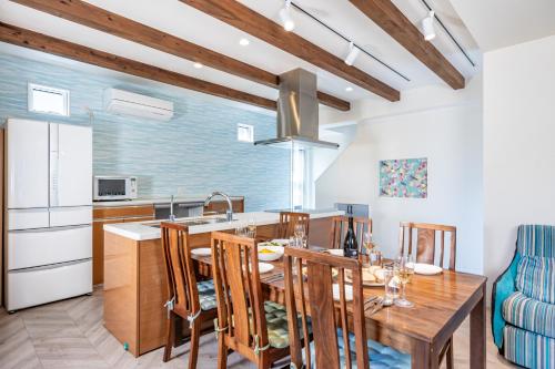 a kitchen and dining room with a wooden table and chairs at Daikyo Engtsuto Villa in Shirahama