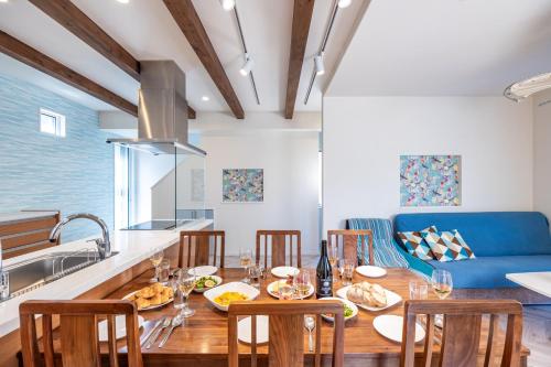 a kitchen and dining room with a table and a blue couch at Daikyo Engtsuto Villa in Shirahama