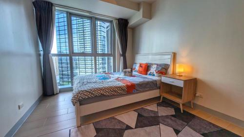马尼拉EG Private House -BGC UPTOWN的一间带床和大窗户的卧室
