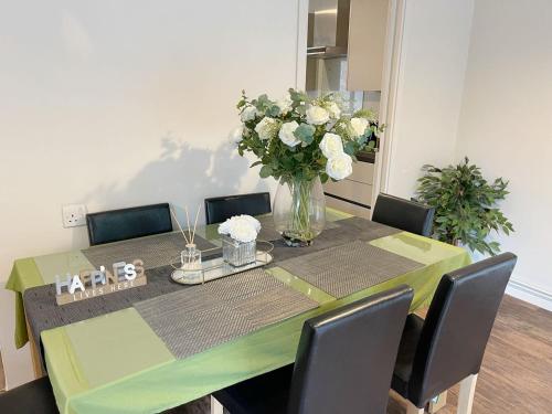 a dining room table with a vase of flowers on it at Oxford University Centre Lovely House in Oxford