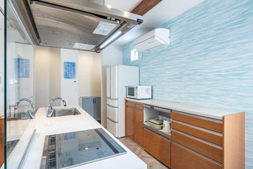 a kitchen with a sink and a refrigerator at Daikyo Engtsuto Villa in Shirahama
