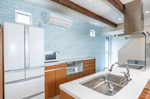 a kitchen with a sink and a refrigerator at Daikyo Engtsuto Villa in Shirahama