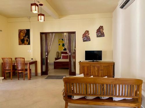 a living room with a couch and a television at Trawangan Nirvana in Gili Trawangan